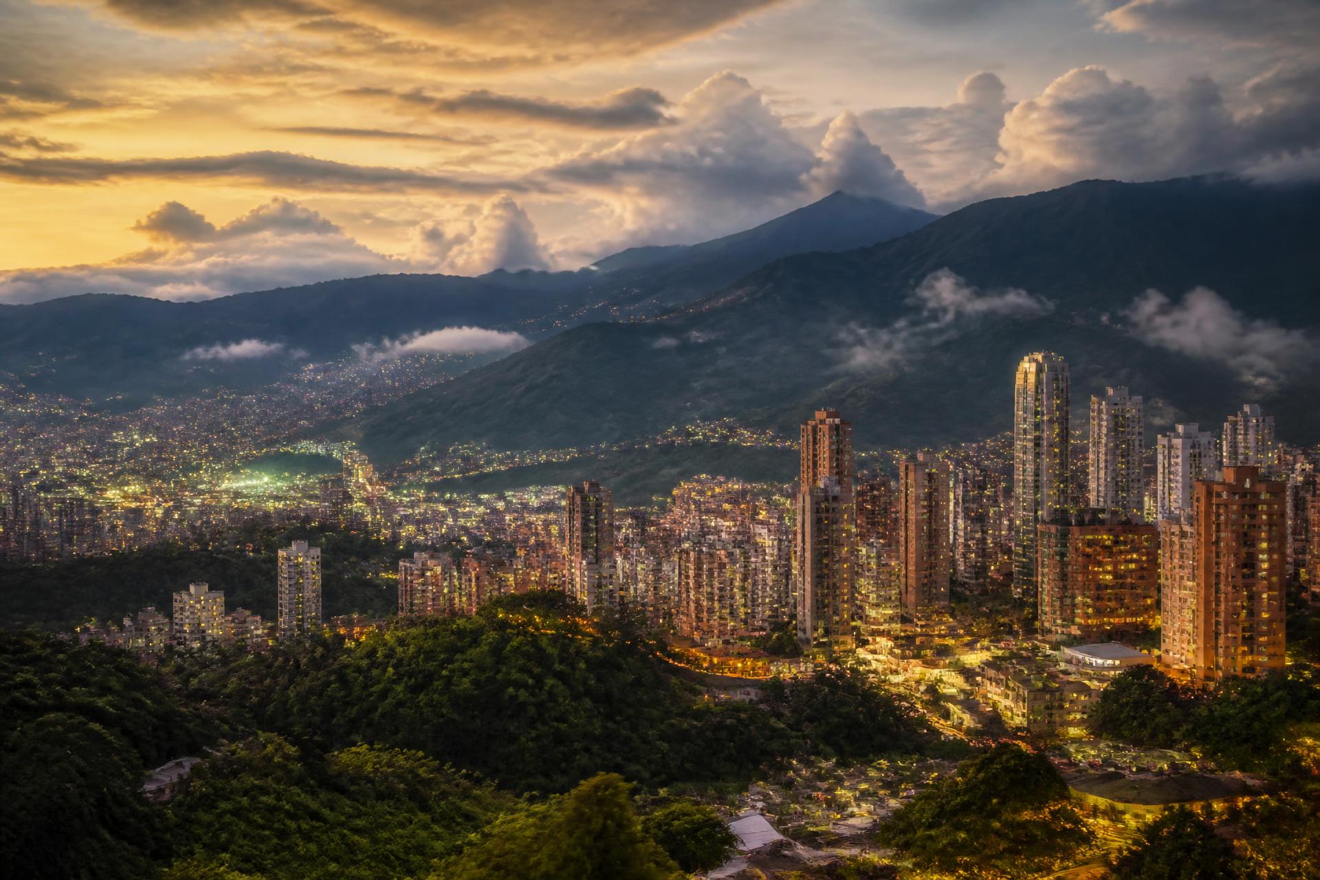 Vista panorámica de Medellín al atardecer con montañas y skyline